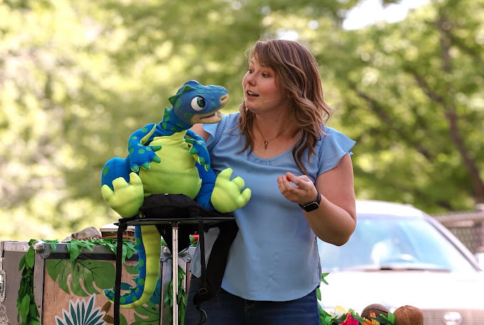 Megan talks with a puppet at an outdoor performance