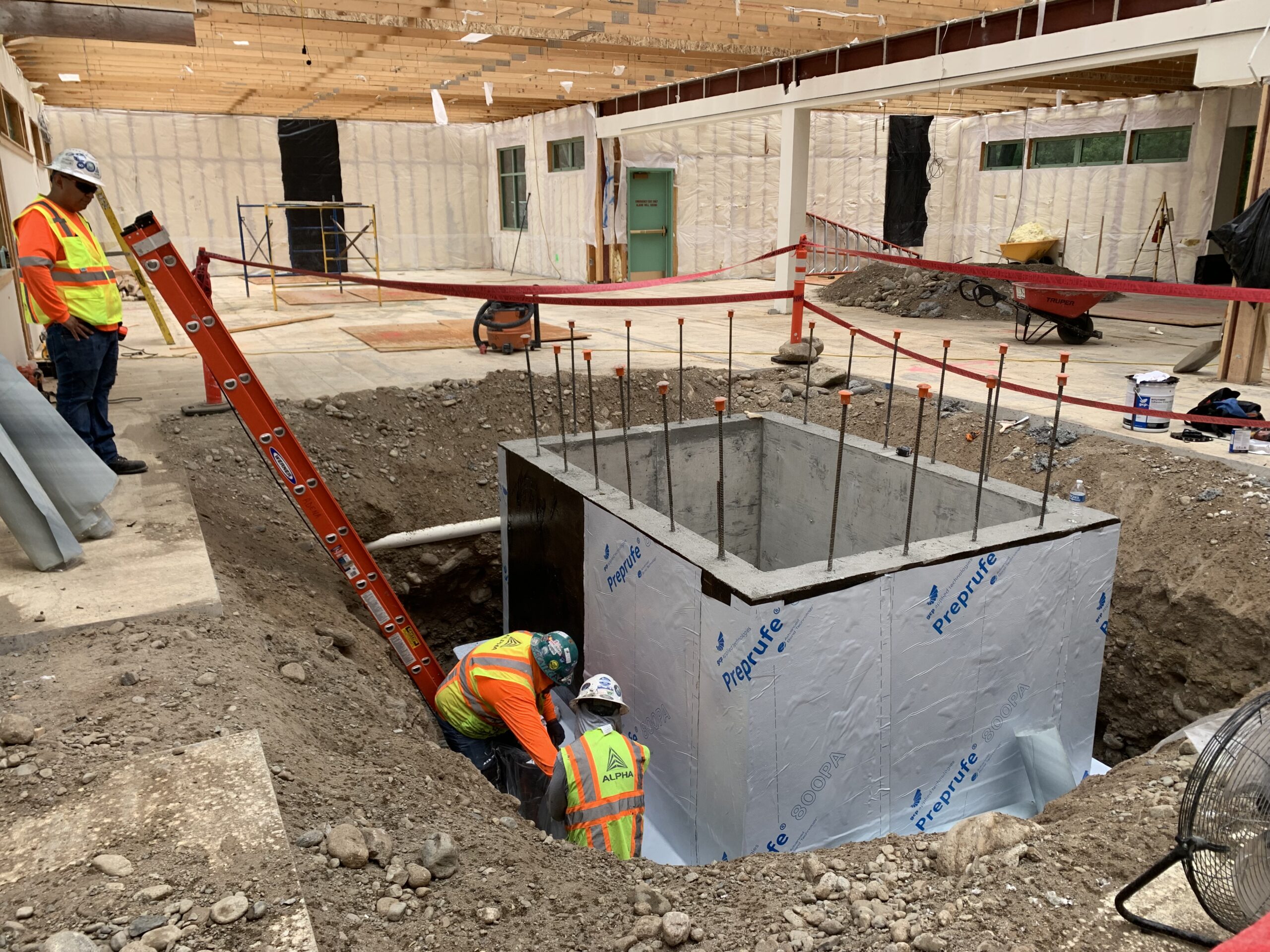 IMG_7209 Crews work to waterproof the elevator pit walls.